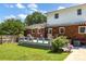 Brick home with back porch and patio, surrounded by a lush, green, fenced backyard at 4121 Dover St, Claremont, NC 28610