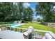 Inviting backyard features a sparkling pool, lush lawn, and comfortable seating area, perfect for outdoor relaxation at 4121 Dover St, Claremont, NC 28610