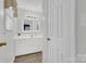 Well-lit bathroom featuring white cabinets, a large mirror, and modern fixtures at 4121 Dover St, Claremont, NC 28610