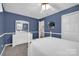 Charming blue bedroom features white furniture, trim and a ceiling fan for comfort at 4121 Dover St, Claremont, NC 28610