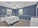 Blue bedroom with white trim, natural light, and comfy furniture and a ceiling fan at 4121 Dover St, Claremont, NC 28610