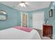 A cozy bedroom features blue walls, white trim, ceiling fan and a glimpse into the hallway at 4121 Dover St, Claremont, NC 28610