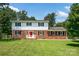 Charming two-story home with a red brick facade and a bright red front door at 4121 Dover St, Claremont, NC 28610