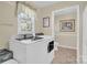 Functional laundry room with modern washer and dryer, window with blinds, and tile flooring at 4121 Dover St, Claremont, NC 28610