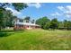 A expansive yard surrounds this two-story home with mature trees at 4121 Dover St, Claremont, NC 28610
