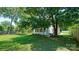 The backyard offers a tranquil spot with a porch swing and a lush green yard shaded by mature trees at 5511 Milhaven Ln, Charlotte, NC 28269
