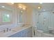 Stylish bathroom with dual sinks, a quartz countertop, and a glass-enclosed shower at 5511 Milhaven Ln, Charlotte, NC 28269