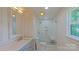 Modern bathroom featuring a walk-in shower with white tile, a niche, and a glass door at 5511 Milhaven Ln, Charlotte, NC 28269