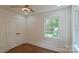 Bedroom with hardwood floors, ceiling fan and view to the outdoors at 5511 Milhaven Ln, Charlotte, NC 28269