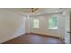 Neutral bedroom with hardwood floors, two windows, and a ceiling fan at 5511 Milhaven Ln, Charlotte, NC 28269