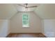 Bedroom with wood floors, ceiling fan, and a window offering natural light at 5511 Milhaven Ln, Charlotte, NC 28269
