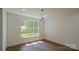 Bright bedroom with hardwood floors, recessed lighting, and a large window at 5511 Milhaven Ln, Charlotte, NC 28269
