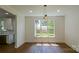 Sunlit dining area with hardwood floors and a large window overlooking the backyard at 5511 Milhaven Ln, Charlotte, NC 28269