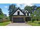 Charming two-story home with stone accents, a black roof, and a well-manicured lawn at 5511 Milhaven Ln, Charlotte, NC 28269