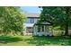 Charming exterior of the home featuring a covered porch, lush greenery, and a well-maintained lawn at 5511 Milhaven Ln, Charlotte, NC 28269