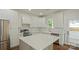 Bright kitchen featuring white cabinets, stainless steel appliances, and a large center island at 5511 Milhaven Ln, Charlotte, NC 28269