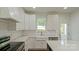 Bright kitchen featuring white cabinets, stainless steel appliances, and a large center island at 5511 Milhaven Ln, Charlotte, NC 28269