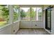 Covered porch with wood flooring, white columns, and a view of the lush green yard at 5511 Milhaven Ln, Charlotte, NC 28269