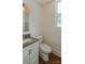 Charming powder room with a modern vanity, toilet, and natural light from a window at 5511 Milhaven Ln, Charlotte, NC 28269
