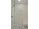 Modern shower with white subway tile, bench, niche, mosaic tile floor, and glass door at 5511 Milhaven Ln, Charlotte, NC 28269