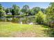 Scenic backyard with grassy area leading to a tranquil lake surrounded by trees at 7039 Executive Cir, Denver, NC 28037