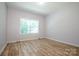 Bright bedroom with wood-look floors and a large window with blinds at 7039 Executive Cir, Denver, NC 28037