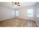 Well-lit bedroom with wood-look flooring, ceiling fan, and large windows at 7039 Executive Cir, Denver, NC 28037