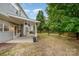 Scenic backyard featuring a patio, green lawn, mature trees, and privacy fencing at 7623 Rathburn Ln, Charlotte, NC 28277