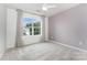 Cozy bedroom with plush carpeting, a modern ceiling fan and natural light from a large window at 7623 Rathburn Ln, Charlotte, NC 28277