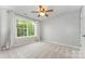 Bright bedroom featuring a ceiling fan and large window offering ample natural light and scenic views at 7623 Rathburn Ln, Charlotte, NC 28277