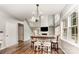 Dining area with a modern chandelier, wooden table, and bar stool seating, filled with natural light at 7623 Rathburn Ln, Charlotte, NC 28277