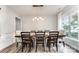 Formal dining room with wood floor, light fixture, table, eight chairs, trim and a window at 7623 Rathburn Ln, Charlotte, NC 28277