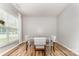 Bright dining room with wood floors, gray walls, white trim, window, and a table with seating for four at 7623 Rathburn Ln, Charlotte, NC 28277