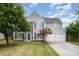 Charming two-story home featuring stone accents, blue shutters, and a well-manicured lawn at 7623 Rathburn Ln, Charlotte, NC 28277