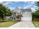 Charming two-story home featuring stone accents, blue shutters, and a well-manicured lawn at 7623 Rathburn Ln, Charlotte, NC 28277