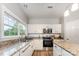 Well-lit kitchen featuring granite countertops, stainless steel appliances, and white cabinetry at 7623 Rathburn Ln, Charlotte, NC 28277