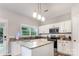 Bright kitchen with granite countertops, a central island, white cabinets, and stainless steel appliances at 7623 Rathburn Ln, Charlotte, NC 28277
