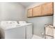 Functional laundry room equipped with a modern washer, dryer, and practical cabinet storage at 7623 Rathburn Ln, Charlotte, NC 28277