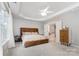 Cozy main bedroom featuring tray ceiling, fan, ensuite bathroom, and a large window at 7623 Rathburn Ln, Charlotte, NC 28277