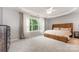 Comfortable main bedroom with a large window, tray ceiling, fan, and neutral decor at 7623 Rathburn Ln, Charlotte, NC 28277
