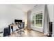 Bright office with a large window, wood floors, computer setup, and comfortable ergonomic chair at 7623 Rathburn Ln, Charlotte, NC 28277