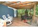 Covered deck with wood floor, metal table and chairs, and white rocking chairs at 792 W Nc Hwy 150 St, Lincolnton, NC 28092