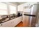 Kitchen features stainless steel refrigerator, black counters, tile backsplash, double sinks, and hardwood floors at 792 W Nc Hwy 150 St, Lincolnton, NC 28092