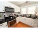 Modern kitchen features white cabinets, stainless steel appliances, black granite countertops and a mosaic tile backsplash at 792 W Nc Hwy 150 St, Lincolnton, NC 28092