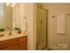 Bathroom featuring a vanity with storage, a shower with a gold frame, and good lighting at 8510 Glade Ct, Huntersville, NC 28078