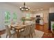 Bright kitchen and dining area with white cabinets, stainless steel appliances, and hardwood floors at 8510 Glade Ct, Huntersville, NC 28078