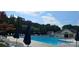 Community swimming pool with lounge chairs, umbrellas, and a bath house at 8510 Glade Ct, Huntersville, NC 28078