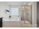 Bright bathroom featuring a soaking tub under a window and a separate glass-enclosed shower at 958 Skywater Dr, Fort Mill, SC 29715