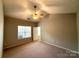Bright bedroom featuring a ceiling fan, window, neutral walls and carpeted floors, providing comfort and style at 9730 Elizabeth Townes Ln, Charlotte, NC 28277
