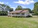 Well-maintained single-story home with a lush green lawn and mature trees surrounding the property at 1302 Hawthorne Rd, Lancaster, SC 29720